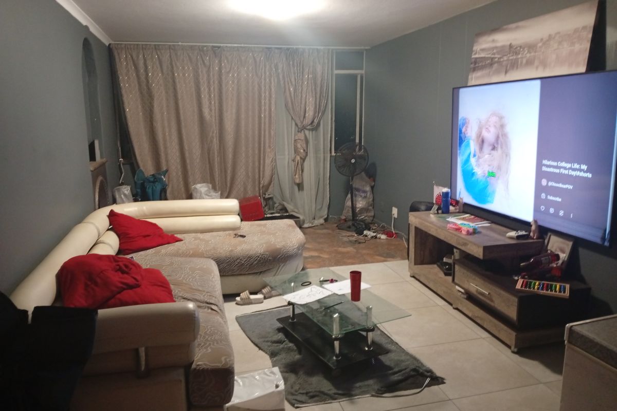 A living room featuring tiled flooring and coved ceilings, providing a functional space for relaxation.