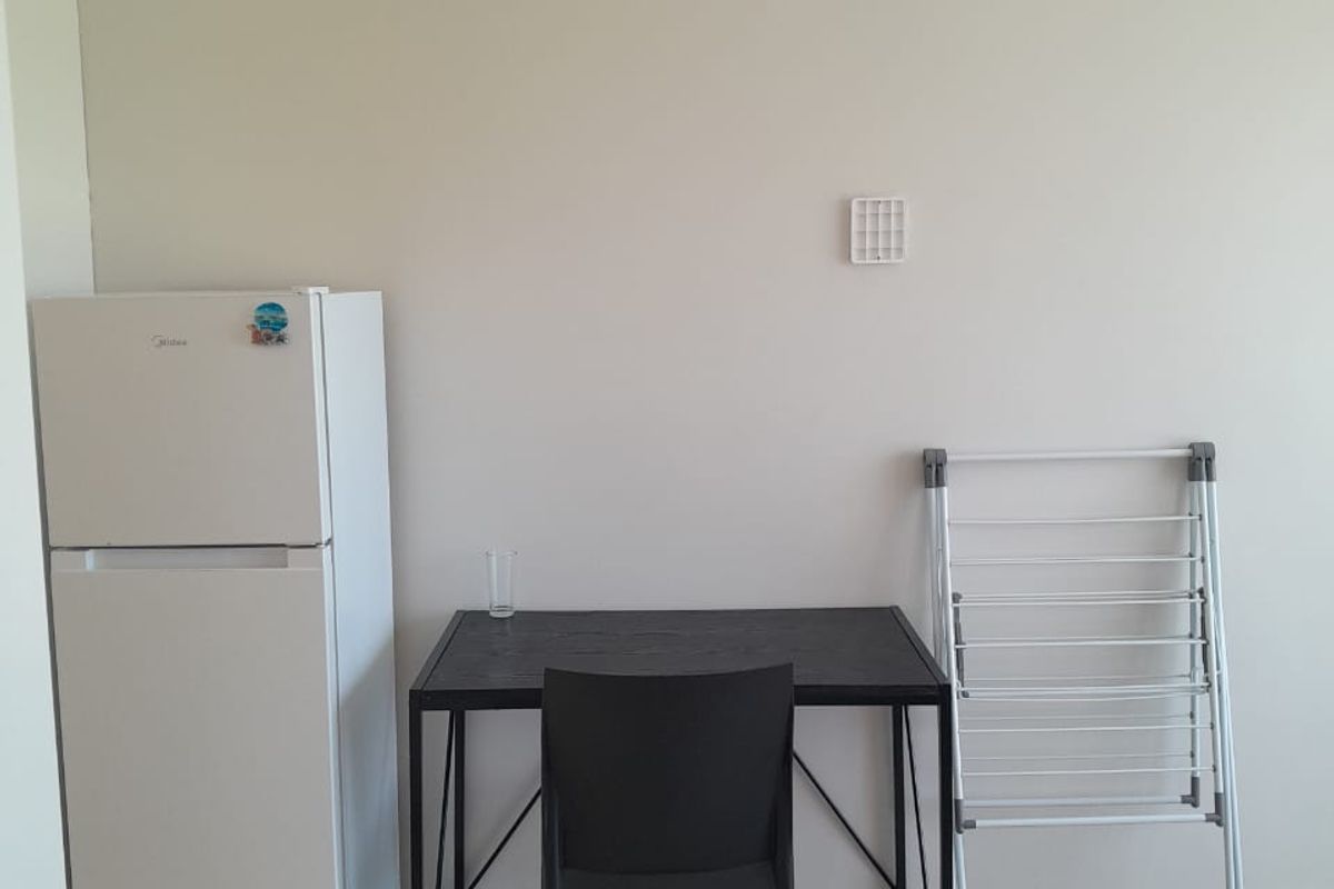 A simple living area featuring neutral wall finishes and tiled flooring, providing a blank canvas for potential interior design and furnishing.