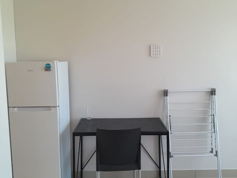 A simple living area featuring neutral wall finishes and tiled flooring, providing a blank canvas for potential interior design and furnishing.