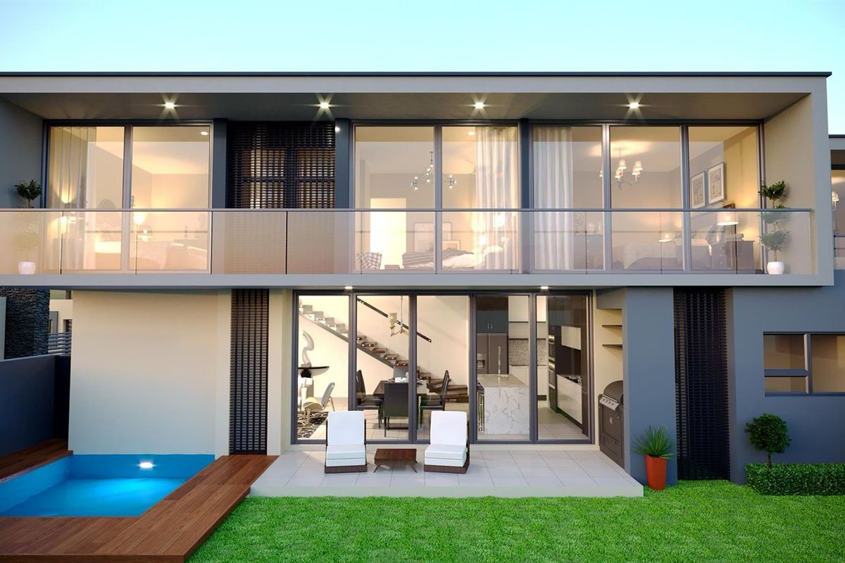 Modern rear exterior view featuring a swimming pool, timber decking, landscaped lawn, and a spacious patio leading into an open-plan living area.