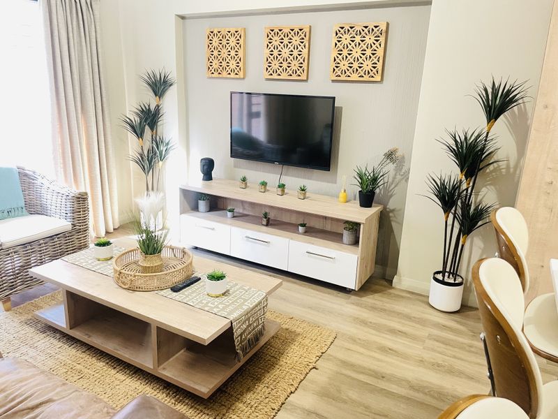 A well-maintained living room featuring light-toned laminate flooring and a dedicated recessed wall niche for media placement.