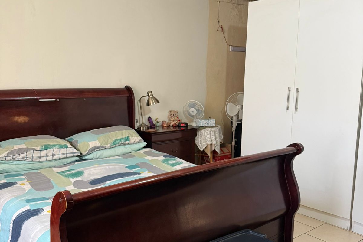 A bedroom featuring tiled flooring and a built-in wardrobe, requiring cosmetic updates to the walls and ceiling to improve the overall finish.