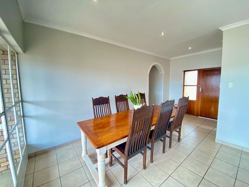 A dining room featuring tiled flooring, recessed downlighting, and a decorative archway leading to an adjacent space.