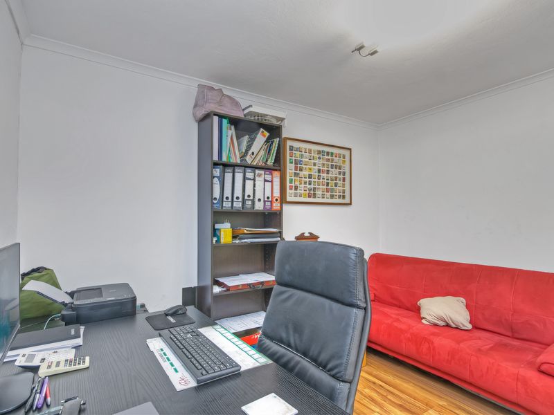 A functional home office space featuring hardwood flooring and neutral wall finishes, suitable for a dedicated workspace or study area.
