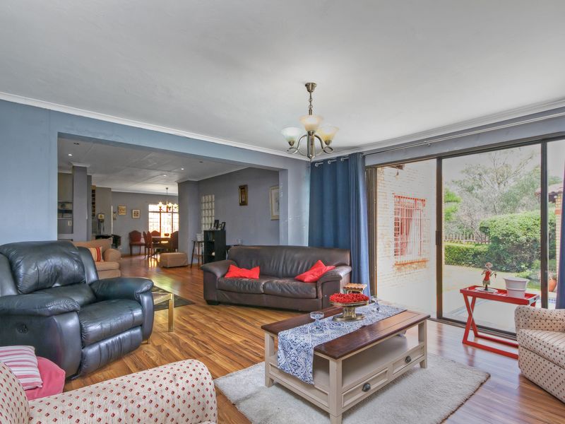 Spacious open-plan living area featuring laminate flooring and large sliding glass doors that provide natural light and access to the outdoor space.