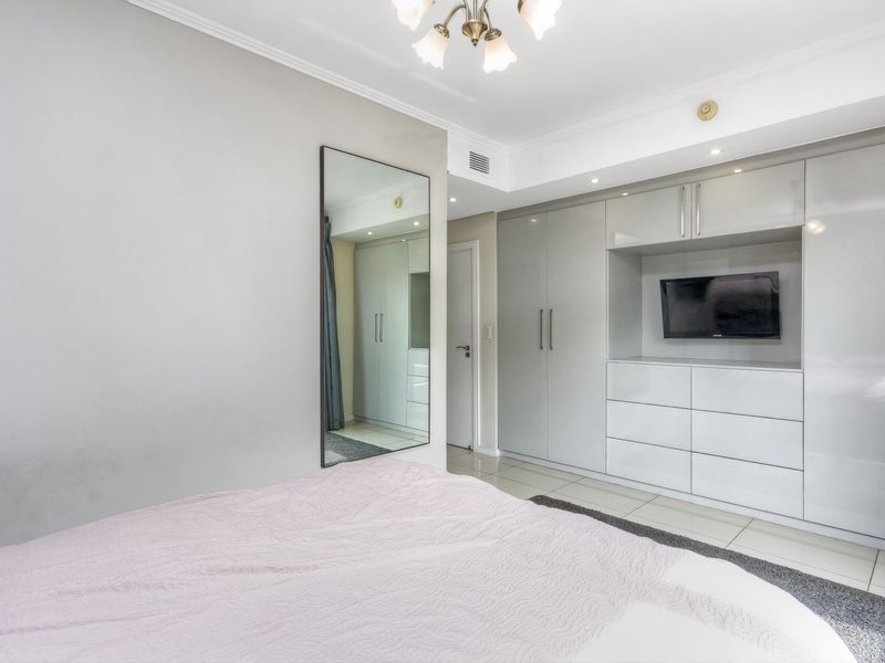 A well-maintained bedroom featuring extensive built-in cabinetry with integrated storage and a sleek, modern finish.
