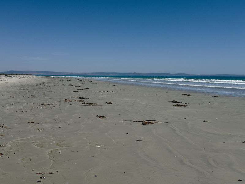 A scenic view of the sandy coastline and ocean, highlighting the natural landscape and beach frontage of the property.