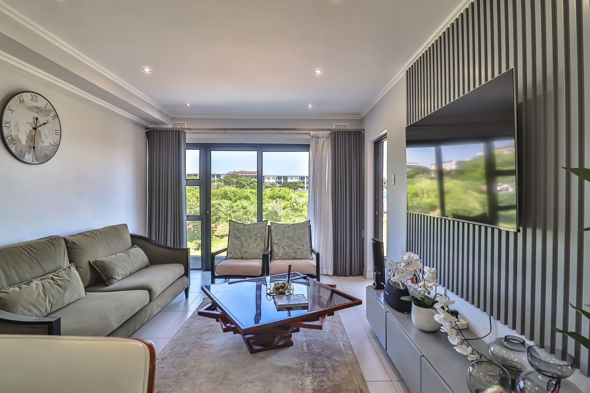 A modern living room featuring a decorative slatted feature wall, tiled flooring, and large sliding glass doors leading to an outdoor area.