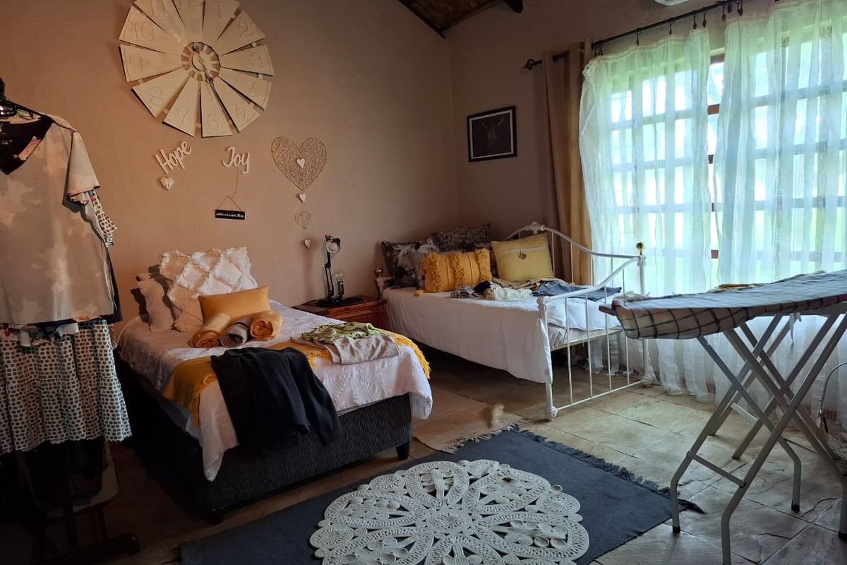 A bedroom featuring vaulted ceilings, tiled flooring, and a wall-mounted air conditioning unit, providing a comfortable living space.