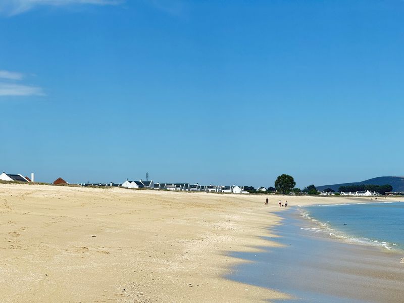 A scenic view of the sandy beach coastline adjacent to the residential property area, showcasing the natural landscape and coastal environment.