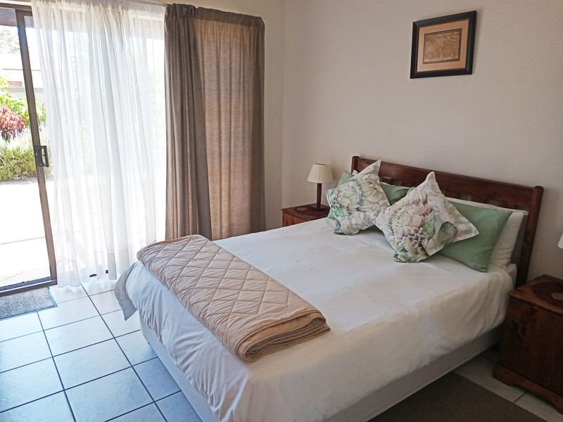 A bedroom featuring tiled flooring and a sliding glass door providing direct access to the outdoor area.