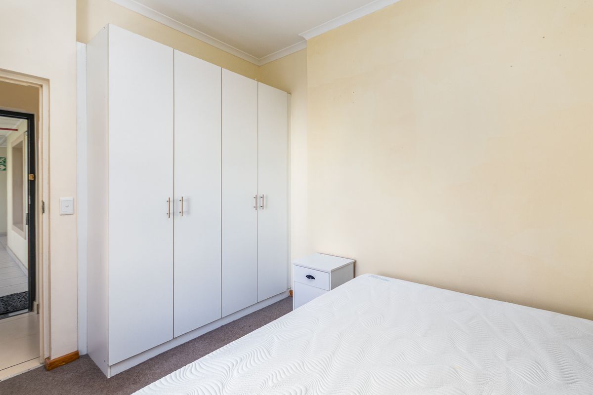A bedroom featuring built-in white cabinetry and neutral wall finishes, providing functional storage space.