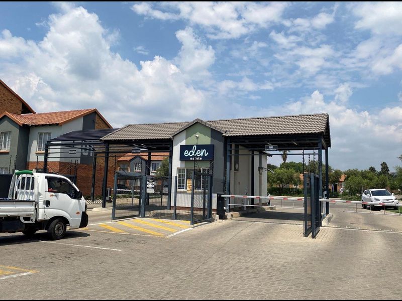 Secure gated entrance to Eden Estate featuring a guardhouse, boom gate access control, and perimeter fencing.