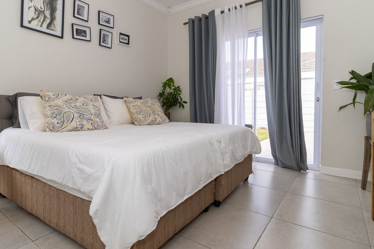 A well-maintained bedroom featuring tiled flooring and a sliding glass door providing direct access to the outdoor area.