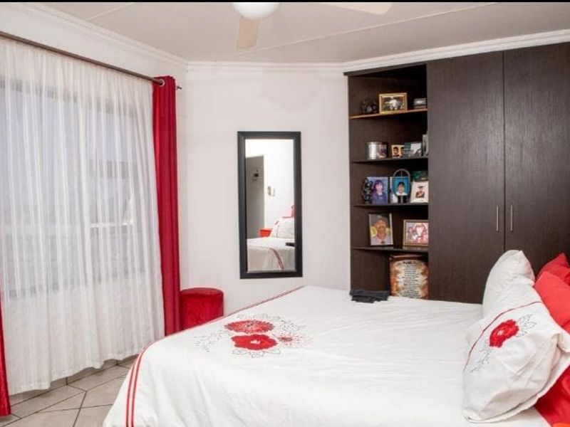A bedroom featuring built-in dark wood cabinetry with integrated shelving and tiled flooring.