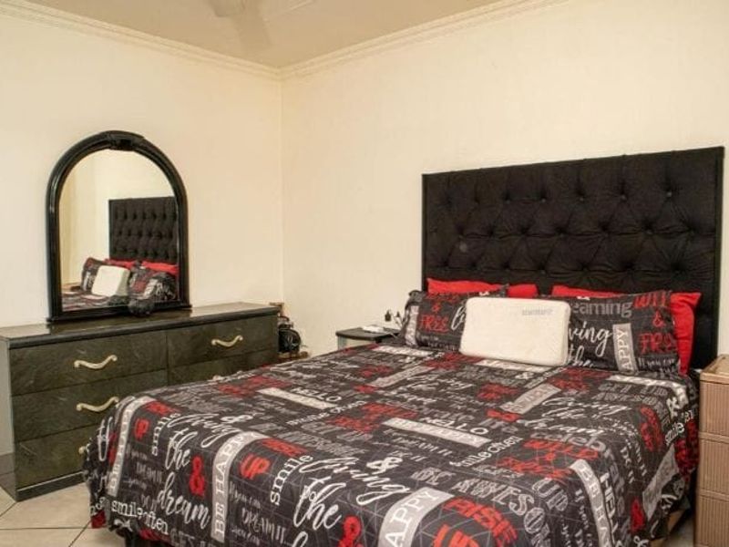 A standard bedroom featuring tiled flooring and neutral wall finishes, providing a functional space for rest.