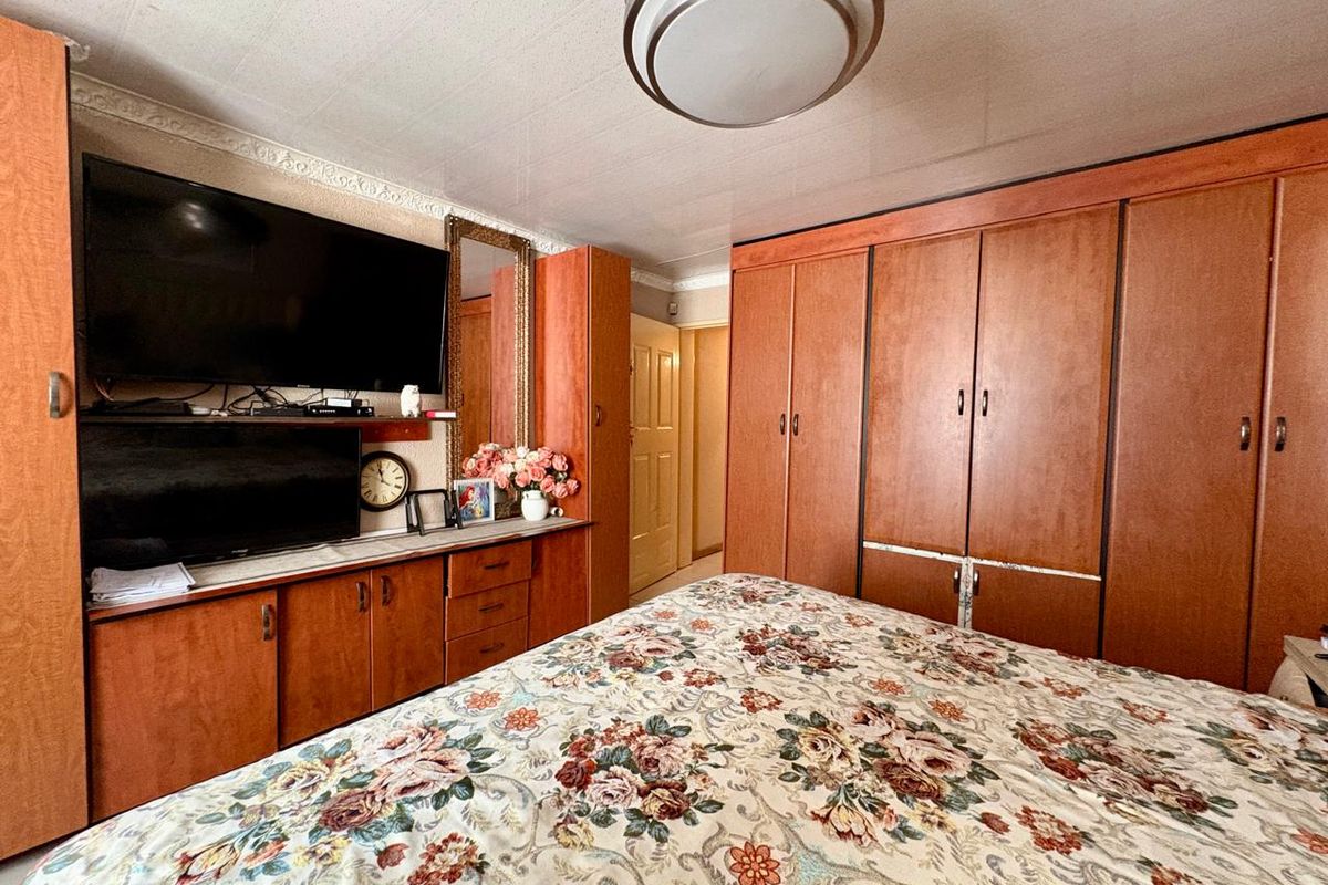 A bedroom featuring extensive built-in wooden cabinetry and storage units, providing ample space for organization and storage.