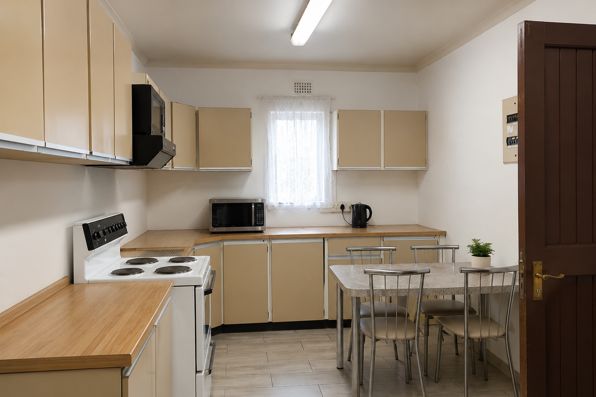 A functional kitchen featuring laminate cabinetry, wood-look laminate countertops, an electric stove with extractor fan, and tiled flooring.