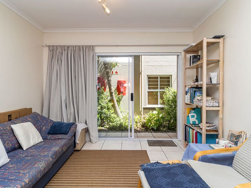 A living room featuring tiled flooring and a sliding glass door providing access to an outdoor area.