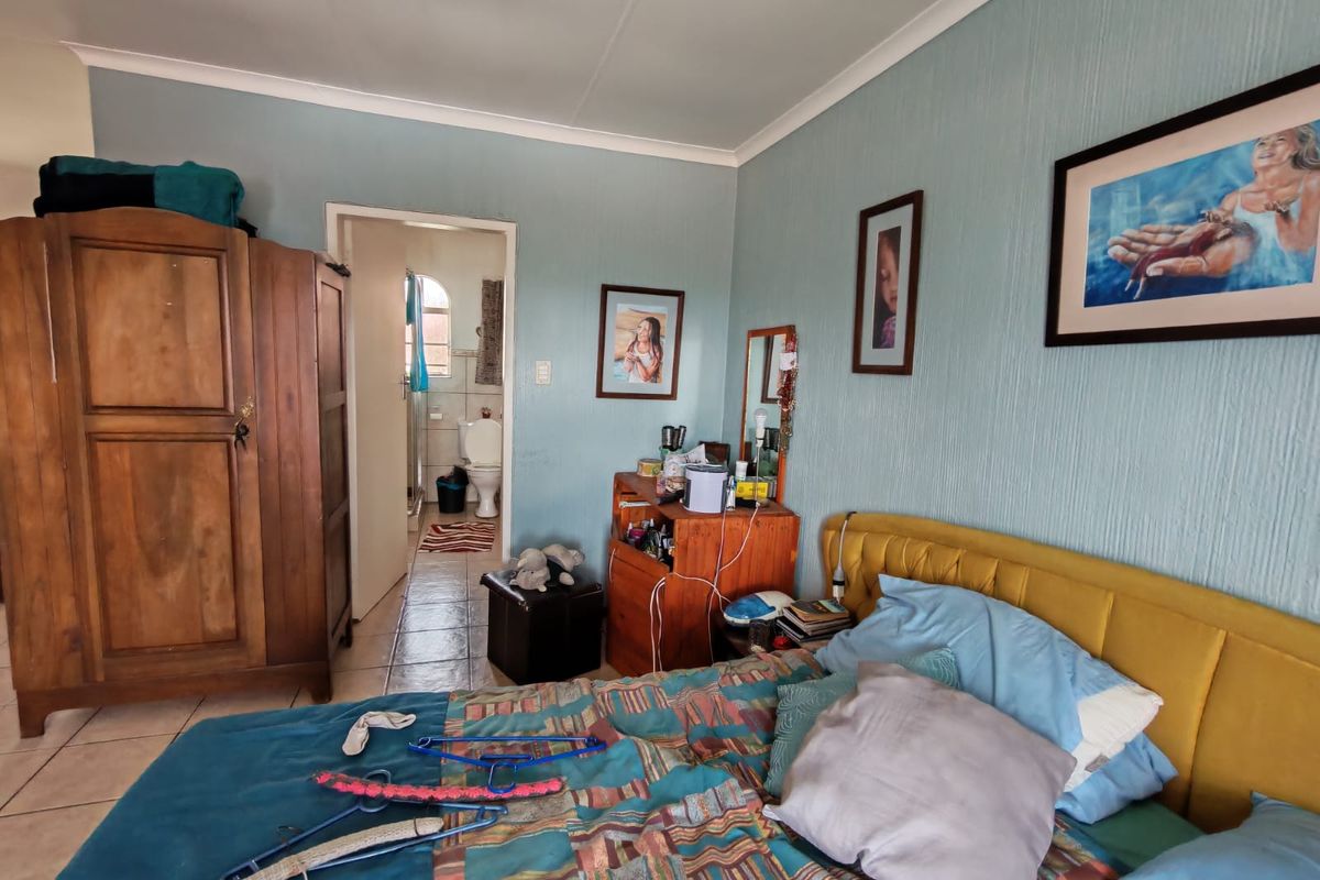 A bedroom featuring tiled flooring and access to an en-suite bathroom, providing a functional layout for a townhouse residence.