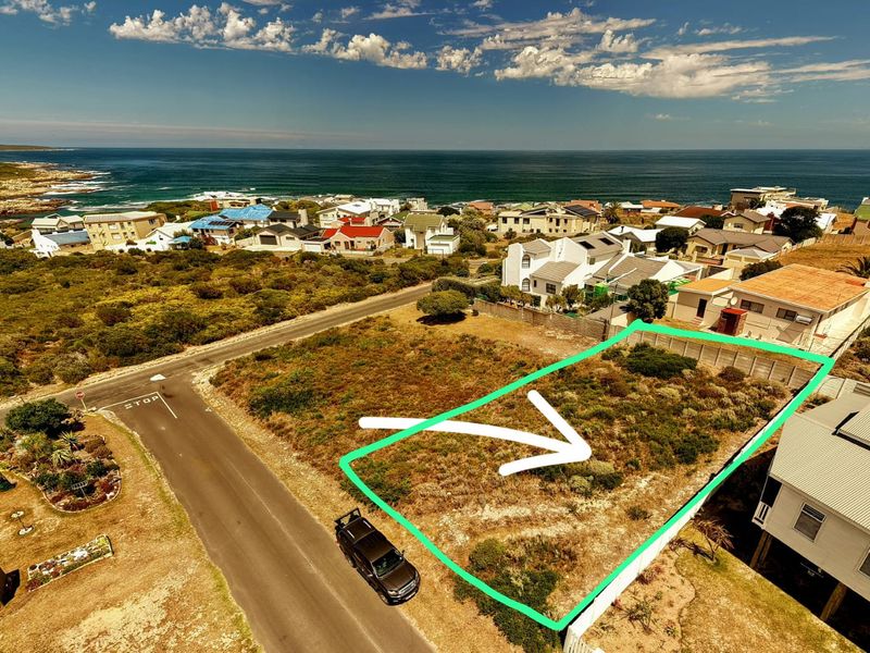 Aerial view of a vacant residential plot situated in a coastal neighborhood, offering potential for development with ocean views.