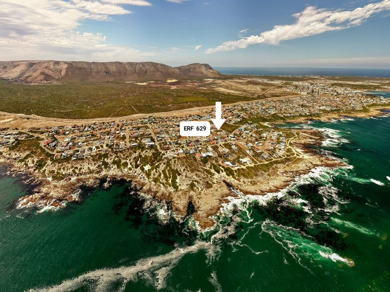 An aerial view of a coastal residential area highlighting the location of the vacant land plot.