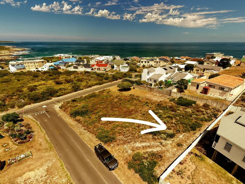 Aerial view of a vacant residential corner plot situated in a coastal neighborhood, offering proximity to the ocean and established residential surroundings.
