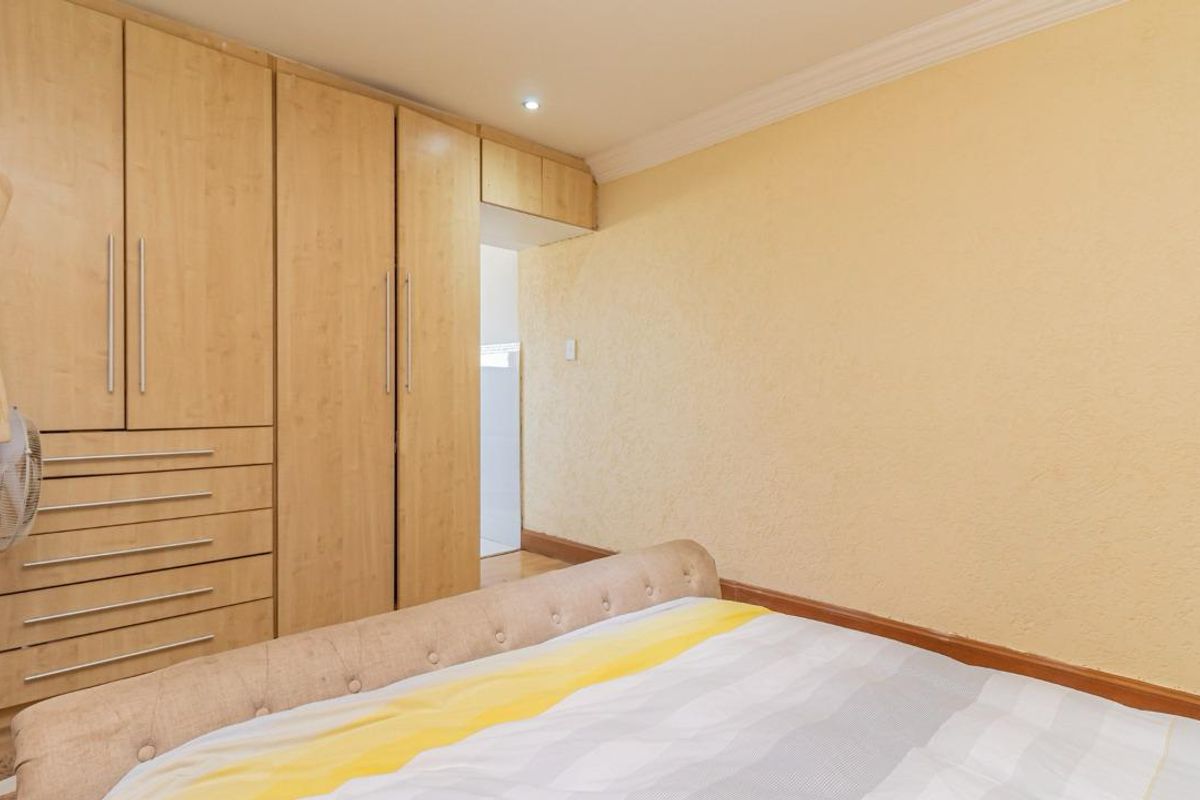 A bedroom featuring built-in wooden cabinetry with integrated drawers and recessed ceiling lighting.