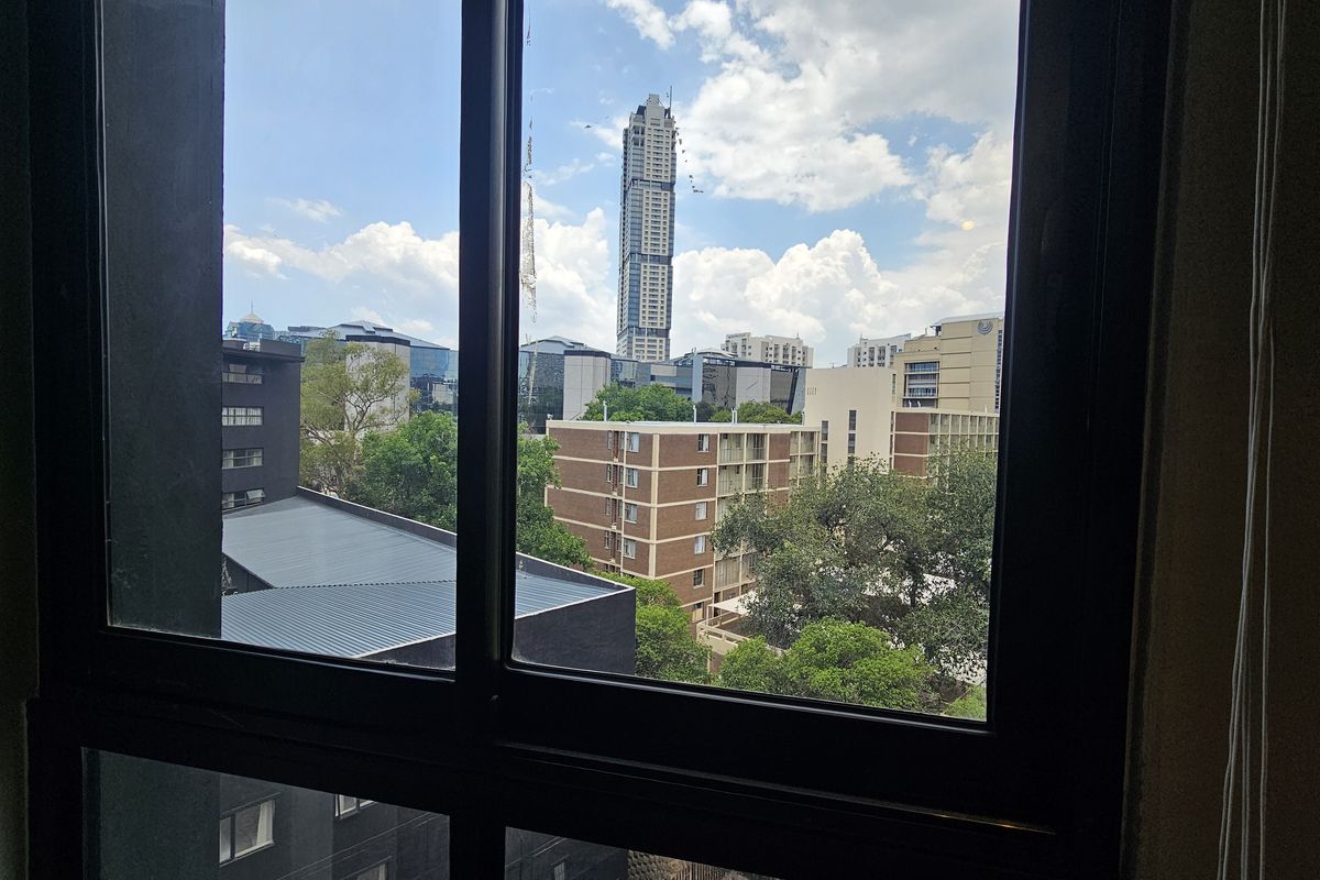 A view from an apartment window overlooking the surrounding urban landscape and city skyline.