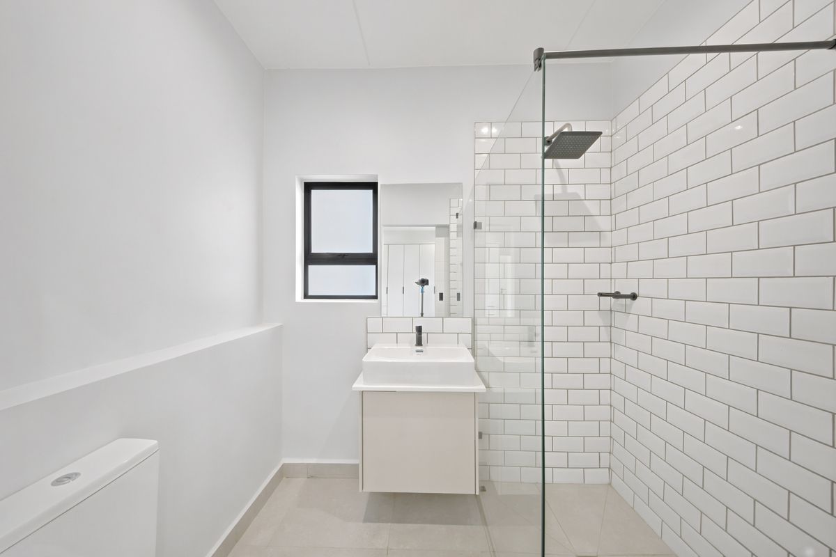 Modern bathroom featuring a walk-in shower with subway tile surround, a floating vanity with basin, and a sleek, minimalist design.