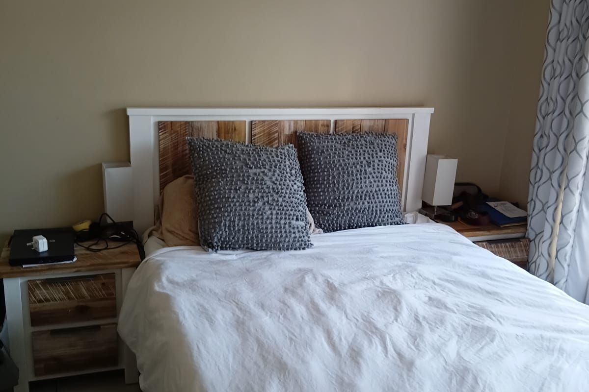A bedroom featuring neutral wall tones and tiled flooring, providing a functional and comfortable sleeping space.
