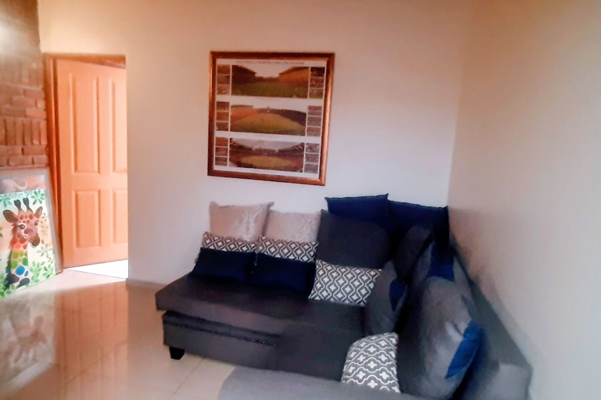 A living room featuring a brick accent wall and tiled flooring, providing a cozy and functional space.