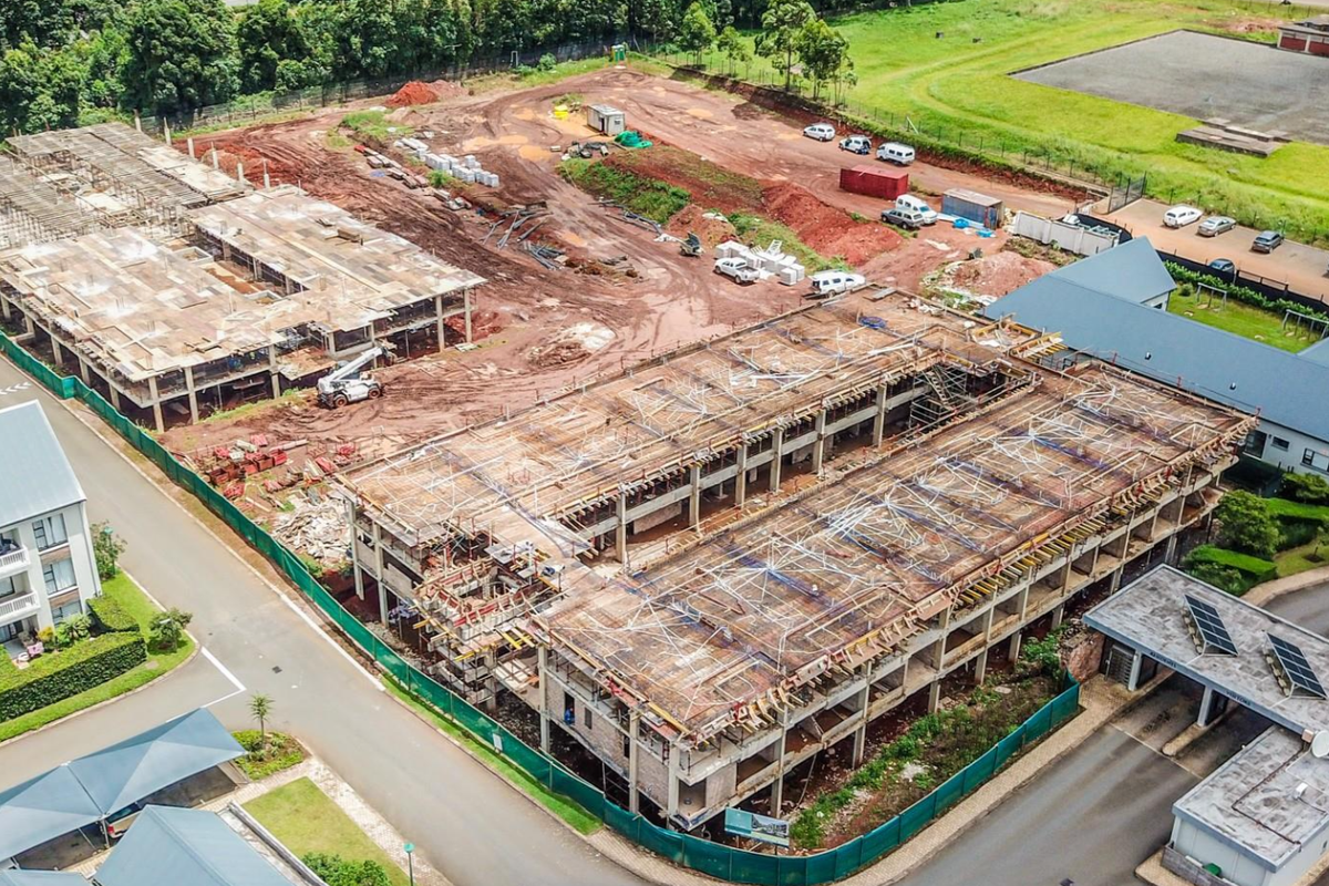 Aerial view of an active apartment development site showing concrete structural frameworks and ongoing construction progress within a residential estate.