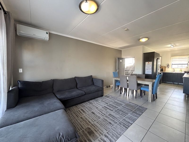 Open-plan living and dining area featuring tiled flooring, split-system air conditioning, and a seamless flow into the adjacent kitchen space.