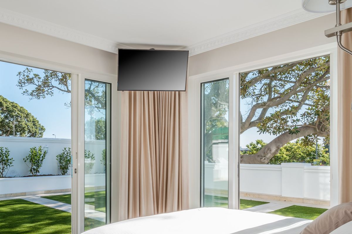 Bright bedroom featuring large sliding glass doors that open directly onto a private garden area, providing ample natural light and outdoor access.