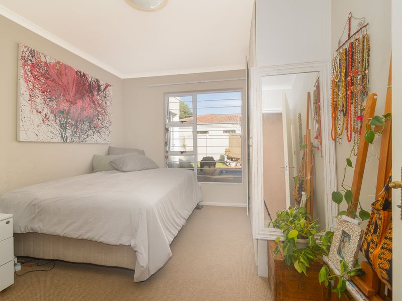A functional bedroom featuring neutral wall tones, carpeted flooring, and a built-in wardrobe, offering a comfortable and practical living space.