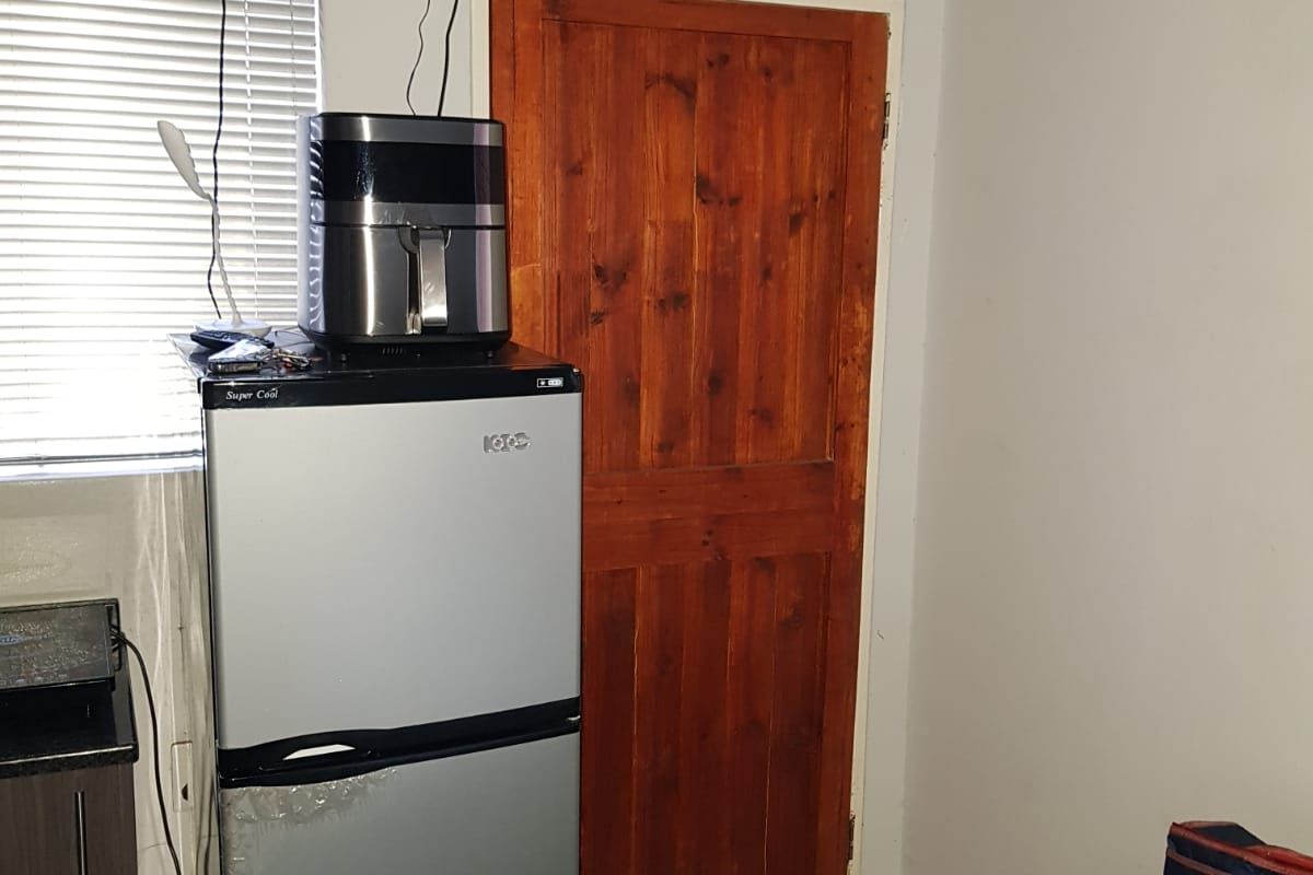 A bedroom interior featuring a solid wood door and venetian blinds, showing standard residential finishes.