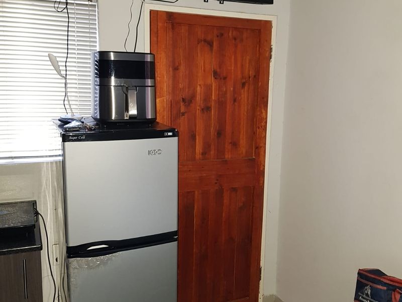 A bedroom interior featuring a solid wood door and venetian blinds, showing standard residential finishes.