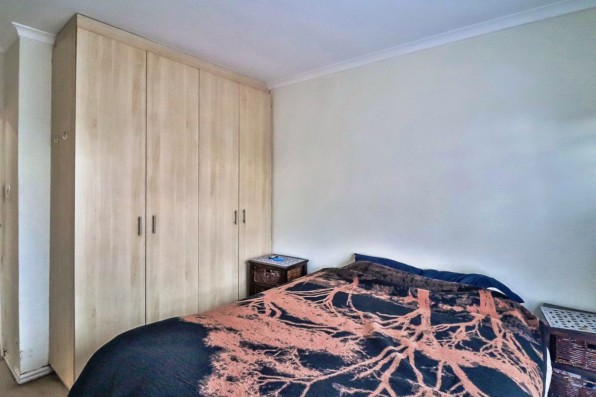 A bedroom featuring light wood-finish built-in wardrobes and coving detail.
