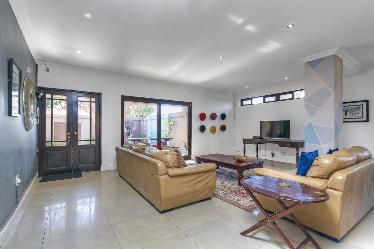 Spacious living room featuring tiled flooring, recessed downlighting, and sliding glass doors providing direct access to the outdoor patio area.