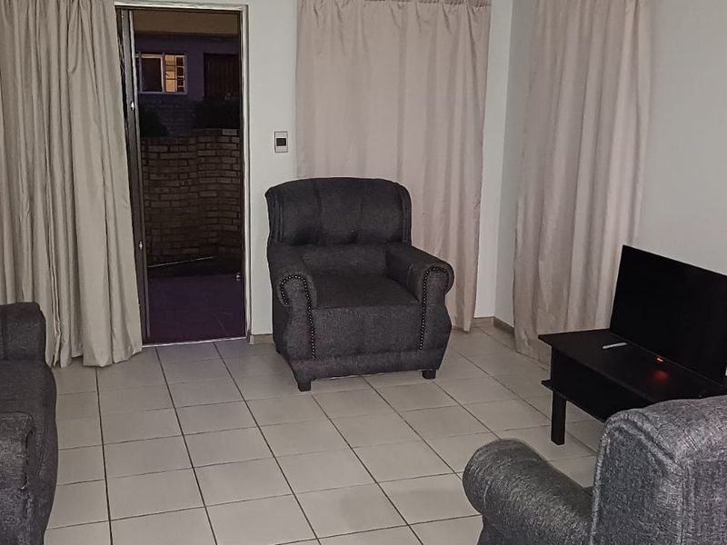A living room featuring tiled flooring and a sliding glass door providing access to an outdoor area.