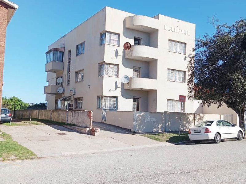 Exterior view of the Bellevue apartment building featuring a multi-story facade, concrete balconies, and a paved driveway area.