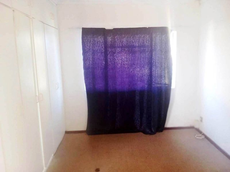 A vacant bedroom featuring built-in cupboards and carpeted flooring, offering a blank canvas for potential updates and interior design improvements.
