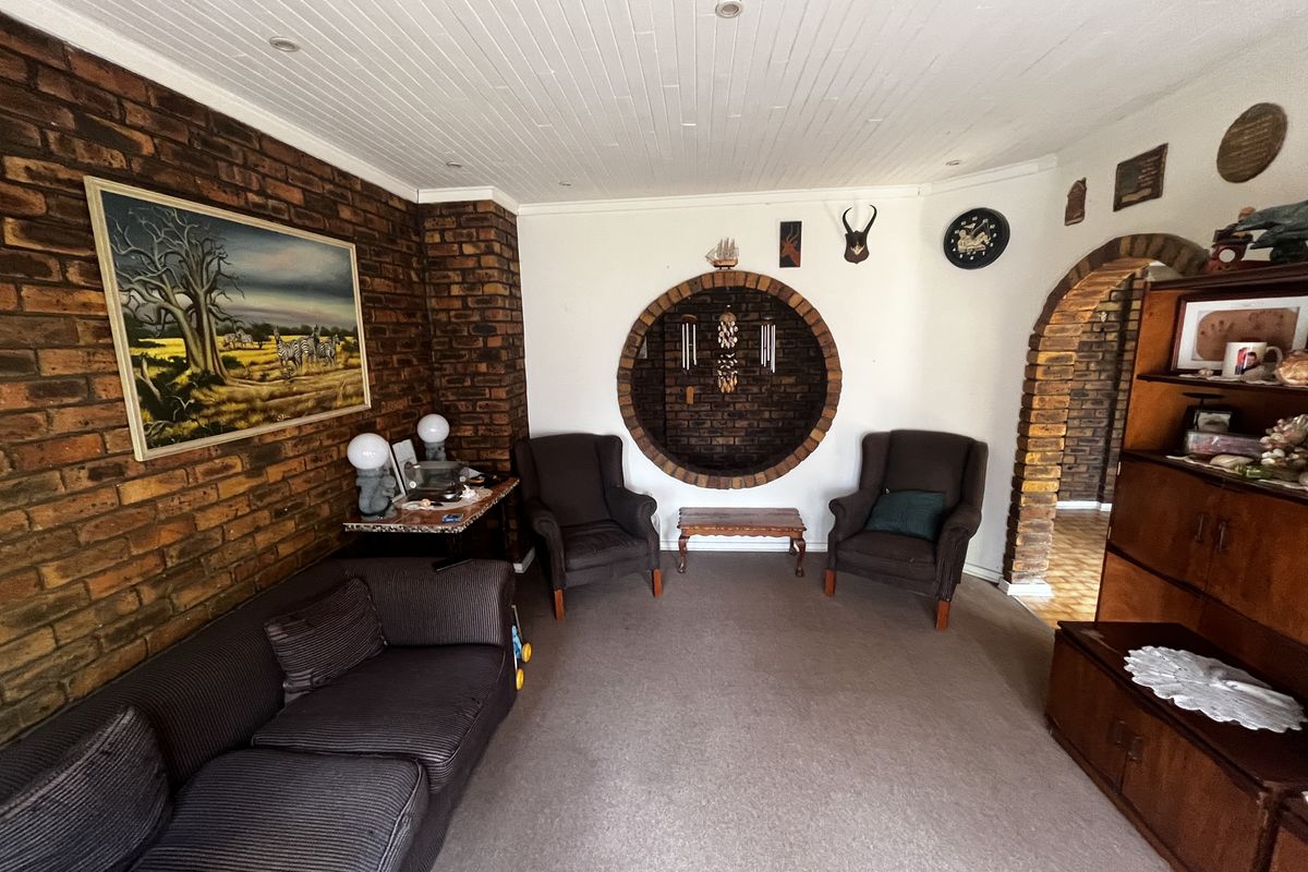 Living room featuring exposed brick walls, a unique circular brick feature, and a classic brick archway leading to an adjacent space.