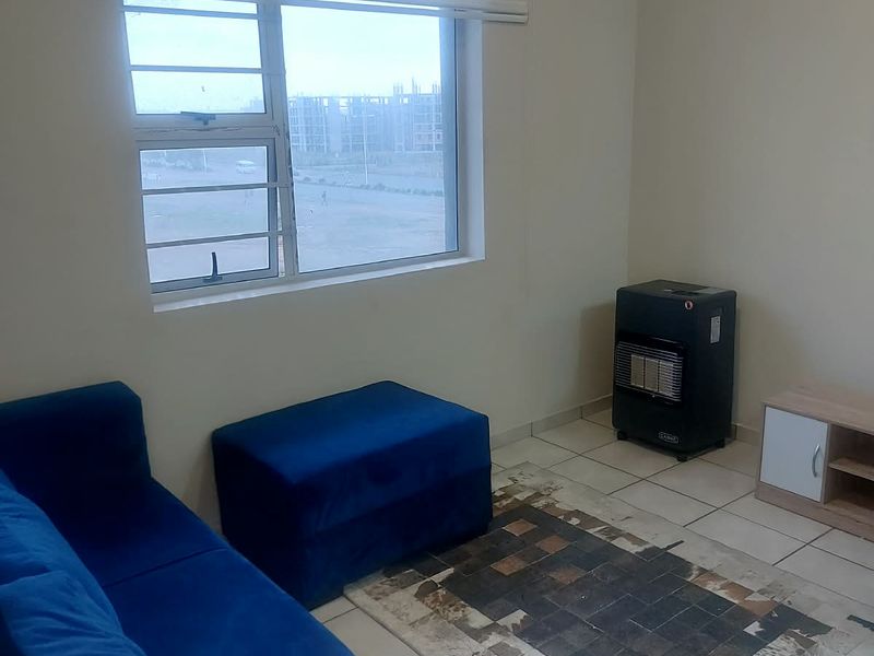 A living room featuring tiled flooring, a window with security bars, and a roller blind, providing a functional and neutral space.