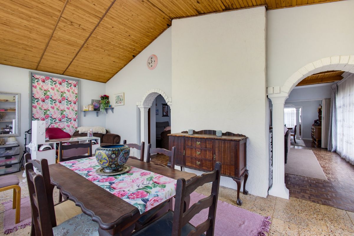 Living area featuring a vaulted timber ceiling, terrazzo flooring, and distinctive arched doorways with decorative columns, creating a unique architectural character.