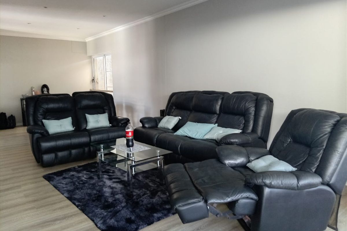 Spacious living room featuring modern laminate flooring and recessed downlighting, providing a neutral and versatile foundation for interior design.