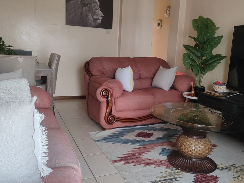 A living room area featuring tiled flooring and neutral wall finishes, providing a functional space for relaxation.