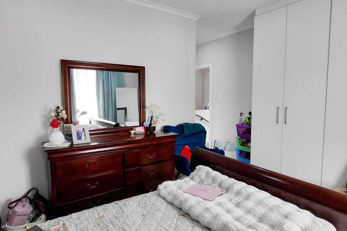 A well-maintained bedroom featuring built-in wardrobes and recessed ceiling lighting, offering a clean and functional living space.