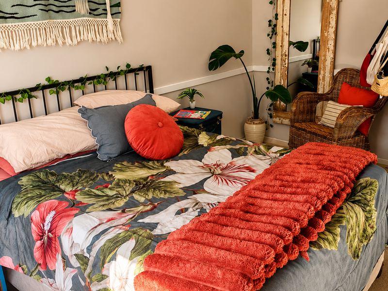 A cozy bedroom featuring neutral wall tones and a decorative chair rail, providing a comfortable and well-maintained living space.